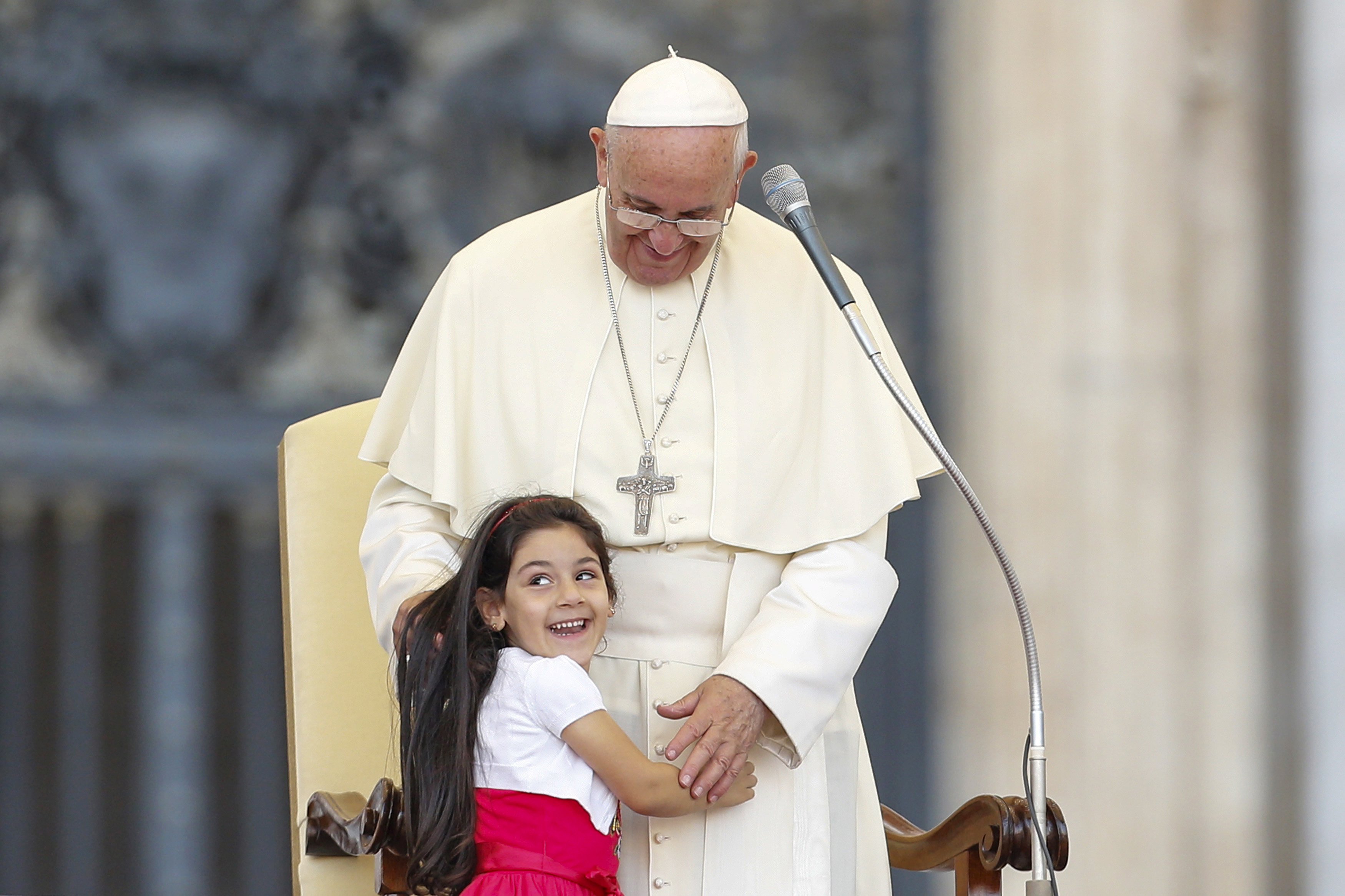 Seorang anak tersenyum ketika memeluk Paus Fransiskus saat memimpin misa bagi peserta Konvensi Keuskupan Roma di lapangan Santo Peter di Kota Vatikan, Minggu (14/6). ANTARA FOTO/REUTERS/Giampiero Sposito.